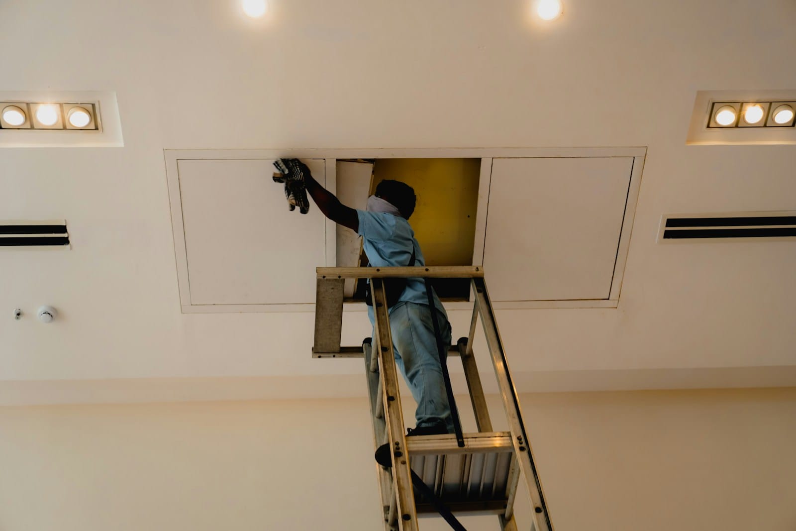 Accès à des combles par une trappe de plafond avec une échelle