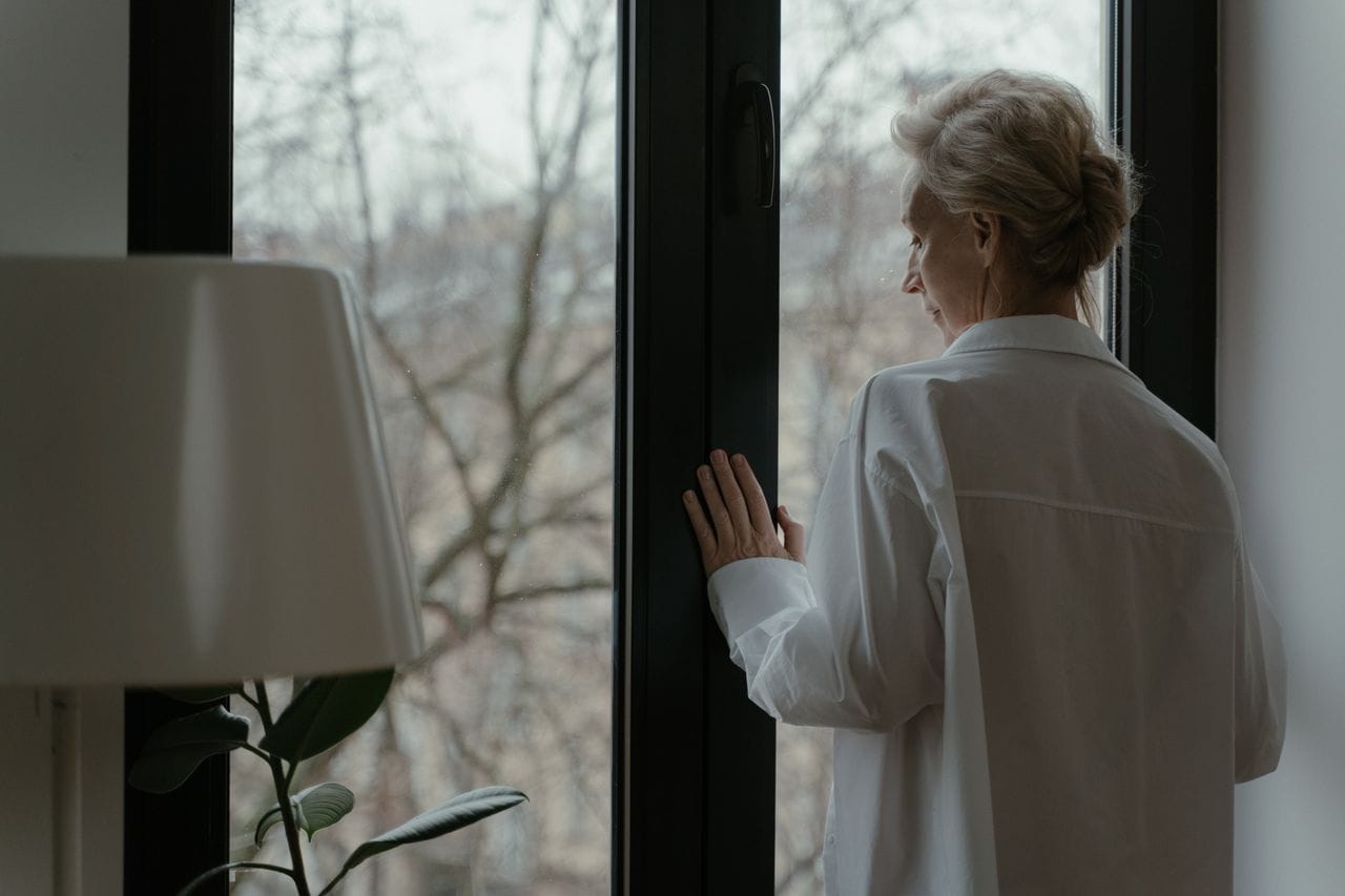 Personne âgée pensive à la fenêtre, syndrome de Diogène chez la personne âgée