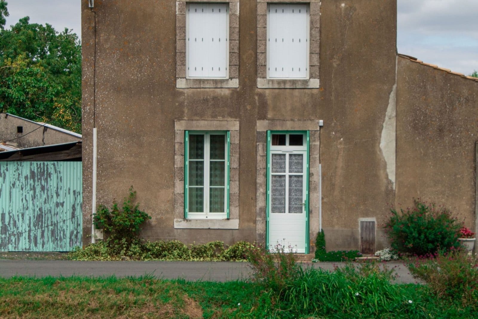Maison ancienne isolée au bord d'une rivière, sous un ciel couvert
