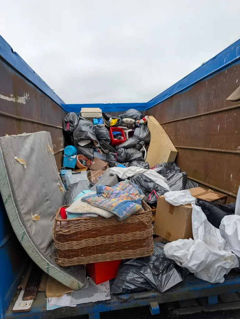 Benne ouverte chargée d'un matelas, de sacs et de cartons après l'évacuation d'un logement