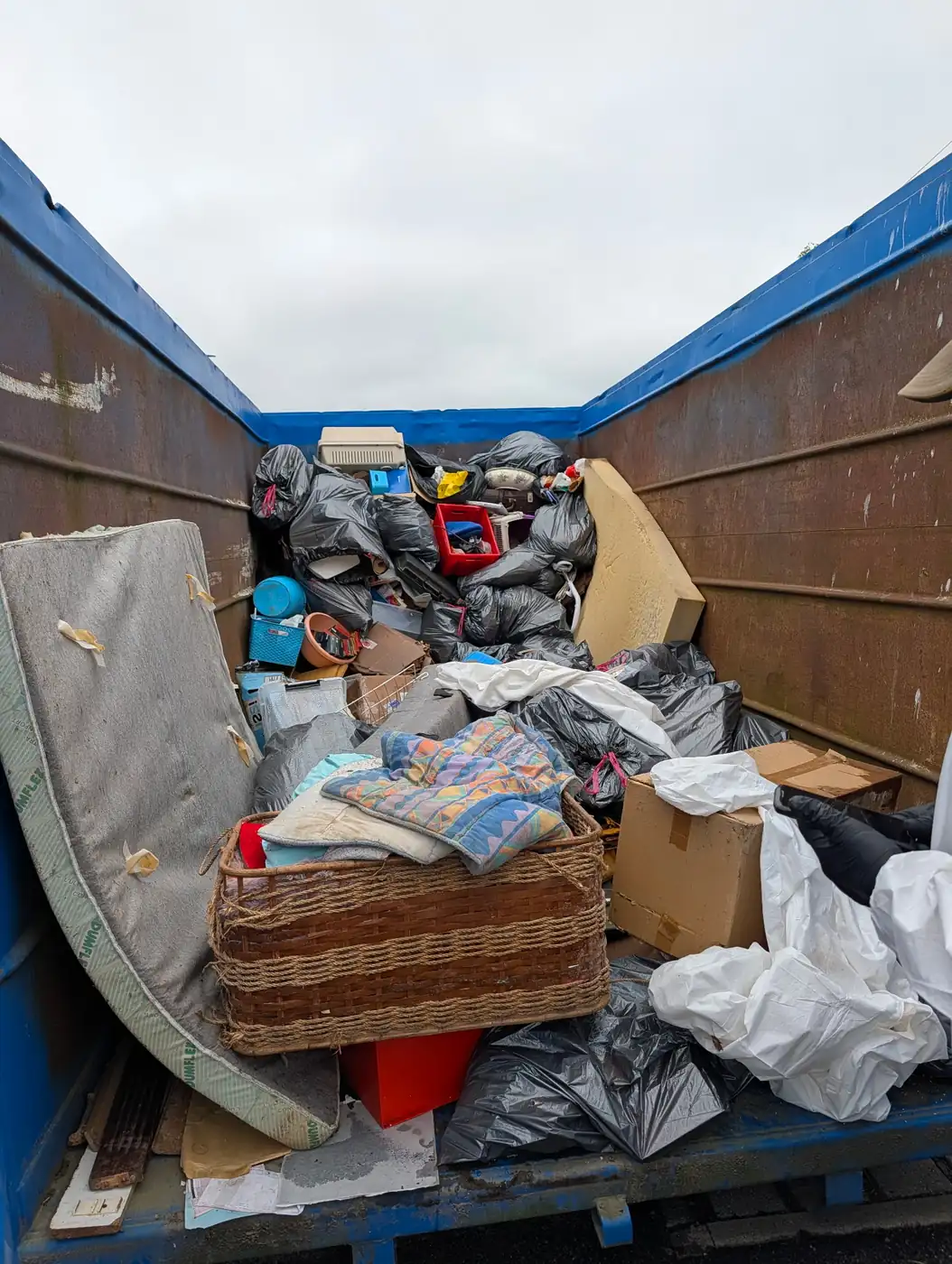 Benne ouverte chargée d'un matelas, de sacs et de cartons après l'évacuation d'un logement