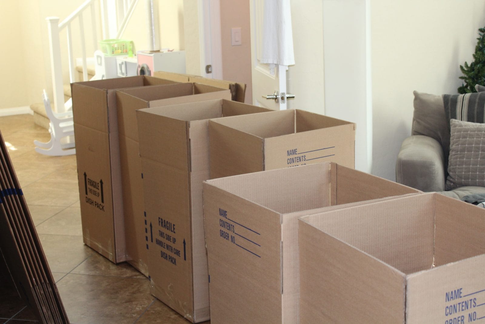 Cartons ouverts dans le salon d'une maison que la famille vide après l'entrée d'un parent en EHPAD